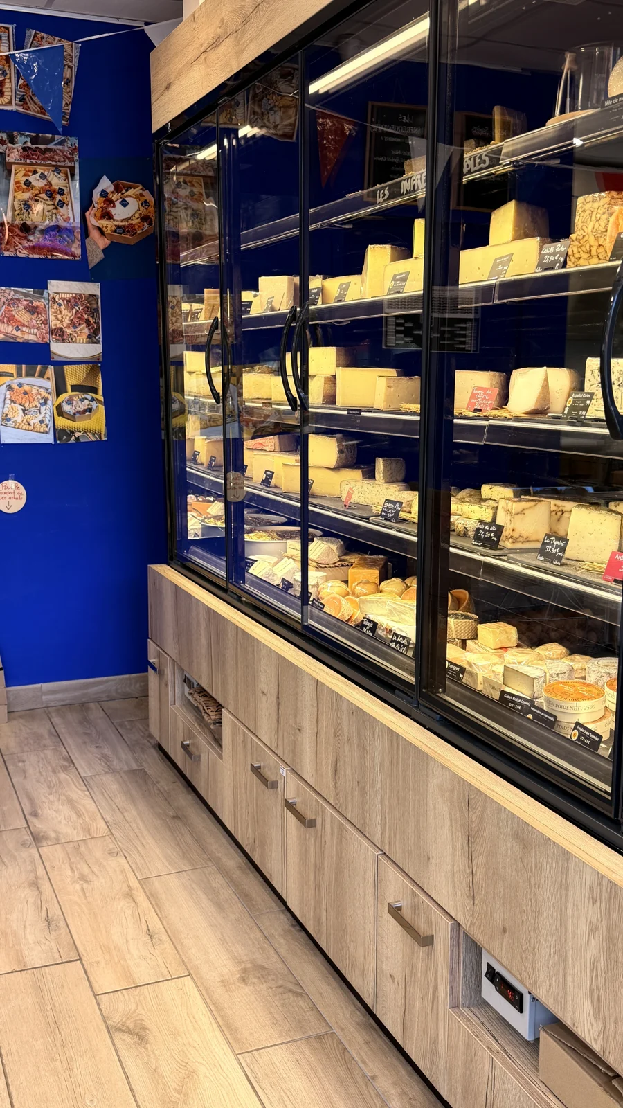 Les vitrines de fromages et le mur bleu de Mirga Bastide