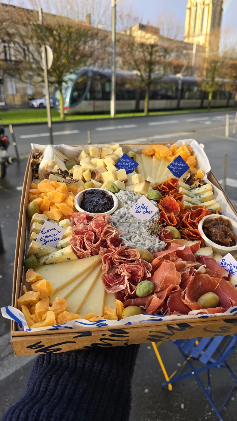 Un plateau mixte porté à bout de bras devant la boutique.